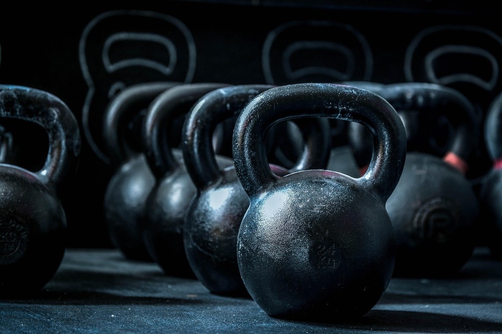 Kettlebell in box, 24 kg in primo piano su pavimento professionale.